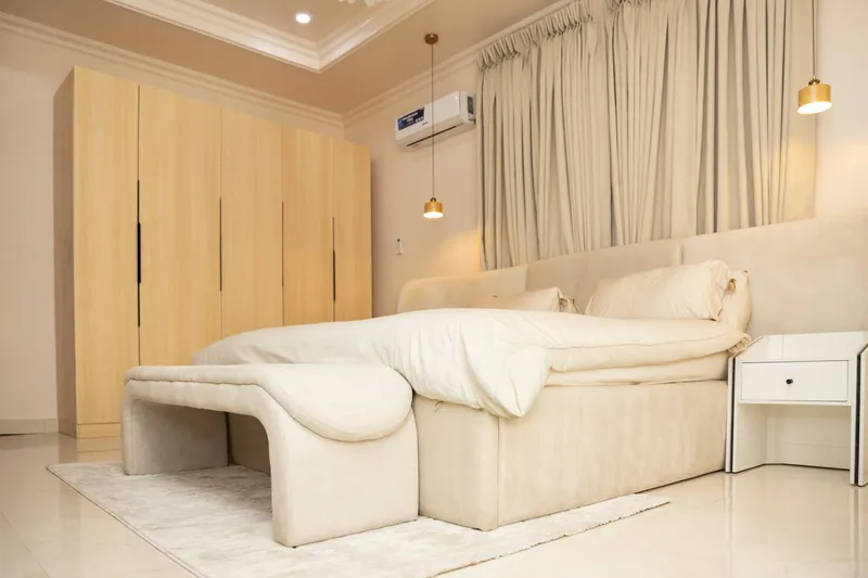 Quarto elegante com cama grande e roupeiros embutidos, com um ar condicionado de parede